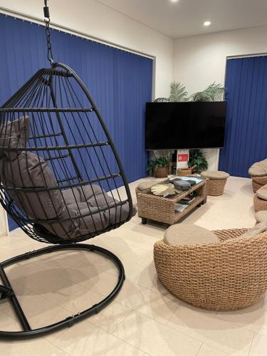 a living room with a hanging chair and chairs at HALE恩納村 Ys Casa in Onna
