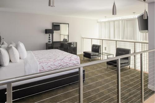 a bedroom with a bed and a balcony with two chairs at Casey Key Resorts - Mainland in Osprey
