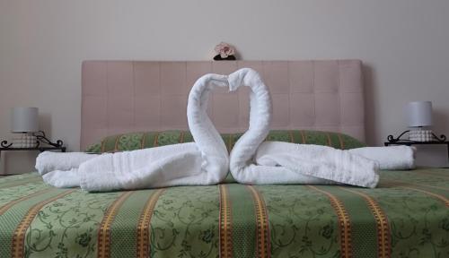 two swans made out of towels on a bed at Il Poderino di Civitavecchia in Civitavecchia