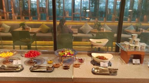 a buffet of food on a table in a restaurant at Qiuguo Hotel Beijing Convention Center Bird's Nest Beiyuan in Beijing