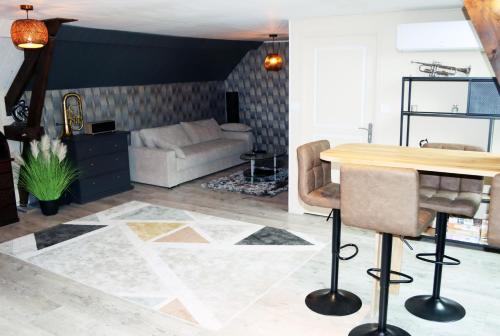 un salon avec une table et un canapé dans l'établissement Logement Cosy type Loft près de Saint Quentin, à Marcy