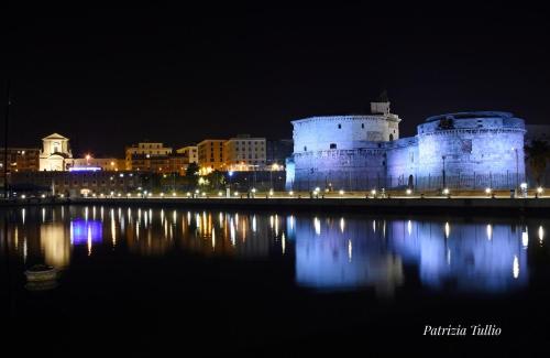 a castle with its lights on the water at night at Il Poderino di Civitavecchia in Civitavecchia