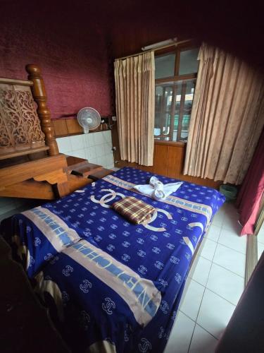 a bedroom with a blue comforter on a bed at Sunny house hostel in Pai