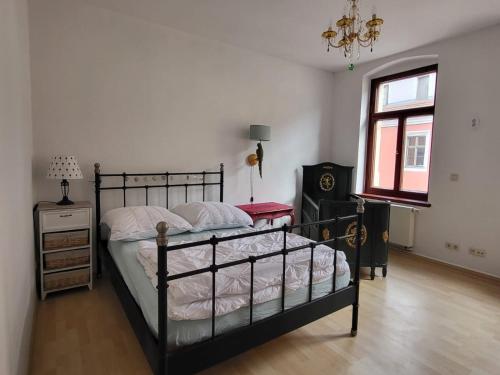 a bedroom with a black bed and a window at Im Herzen der historischen Altstadt mit Elbblick und Balkon in Pirna