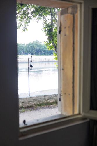 - une fenêtre avec vue sur une étendue d'eau dans l'établissement Charmante maison en Arles : La Roquette, à Arles