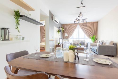 a dining room table with chairs and a living room at NaiBnB in Impiria Residensi in Klang