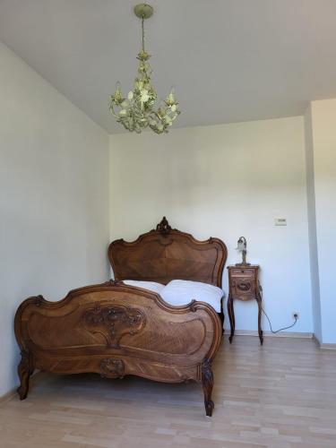 a bedroom with a wooden bed and a chandelier at Im Herzen der historischen Altstadt mit Elbblick und Balkon in Pirna