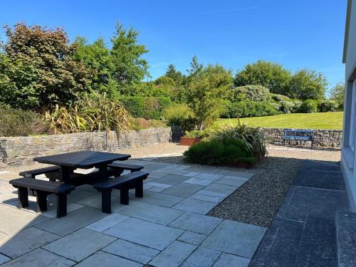 a picnic table and bench on a patio at Ballinakill Lodge in Moyard