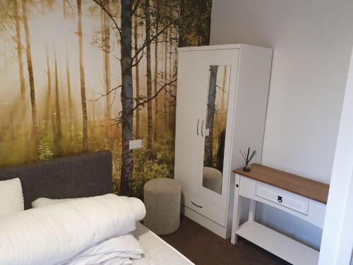 a bedroom with a wall with a forest mural at Beacon View Lodge in Lancashire in Longridge