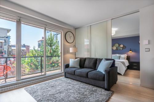 a living room with a couch and a large window at Sun-Drenched Sophistication in Victoria