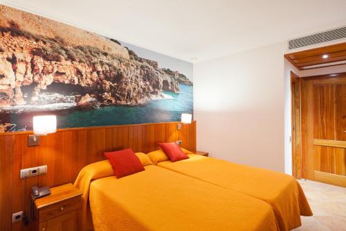 Un dormitorio con una cama amarilla con una pintura en la pared en Plaça De La Font, en Tarragona