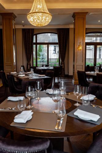 a restaurant with wooden tables and chairs and a chandelier at Hotel Erdeli by Derenivska Kupil in Nyzhne Solotvyno