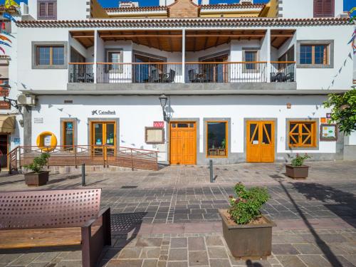a building with orange doors and benches in a courtyard at Texeda Room Suites in Tejeda
