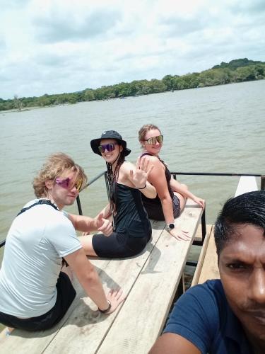 three women sitting on a boat on the water at SIGIRI HUNTER'S HOMESTAY & Hostel in Sigiriya