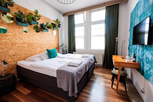 a hotel room with a bed and a desk and a television at Hotel Auberge Nassau in Eindhoven