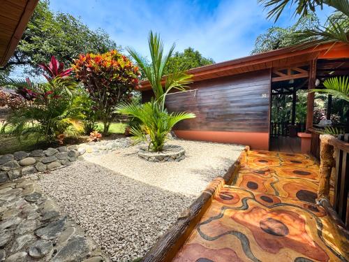 a garden with a house with a mosaic floor at Hotel Heliconias Nature Inn & Hot Springs in Fortuna