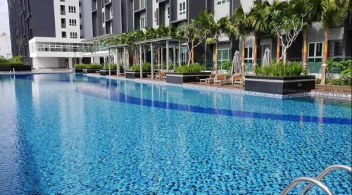 a large blue swimming pool with chairs and buildings at Lazy Cozy Summer Afternoon Healing Daily Life in Klang