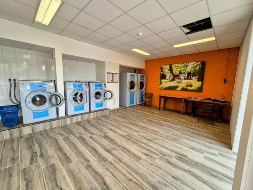 a laundry room with four washing machines and a desk at Chalet V31 in Makkum