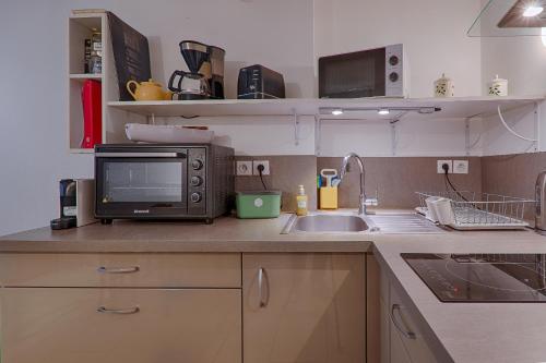 a kitchen with a microwave and a sink at Au Epicéah, logement à la campagne in Valence