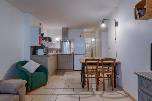 a kitchen with a table and a green couch and a table and chairs at Au Epicéah, logement à la campagne in Valence