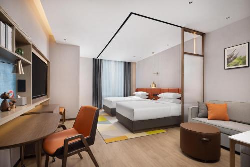 a hotel room with two beds and a desk at Home2 Suite by Hilton Jingjiang Binjiang New Town in Jingjiang