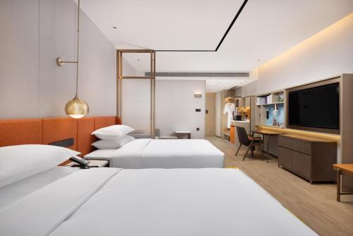 a hospital room with two beds and a flat screen tv at Home2 Suite by Hilton Jingjiang Binjiang New Town in Jingjiang