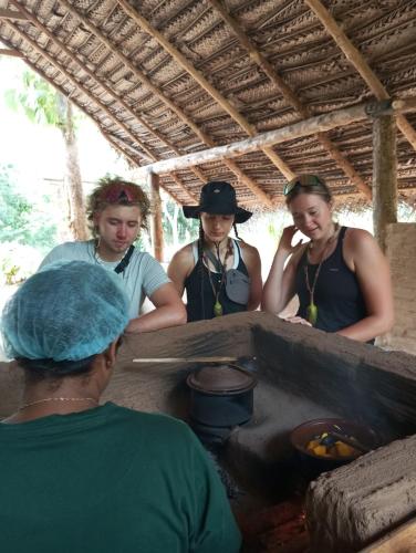 a group of three women standing around a stove at SIGIRI HUNTER'S HOMESTAY & Hostel in Sigiriya
