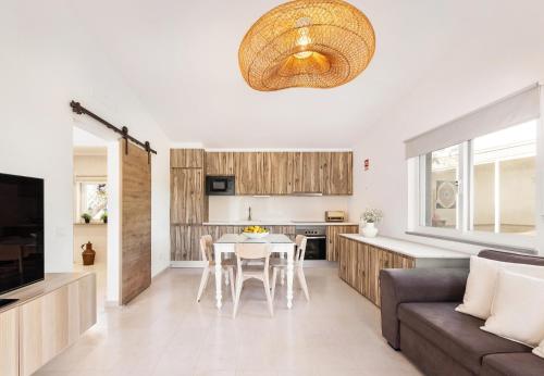a kitchen and living room with a table and a couch at Quinta das Pedras - Tavira in Tavira