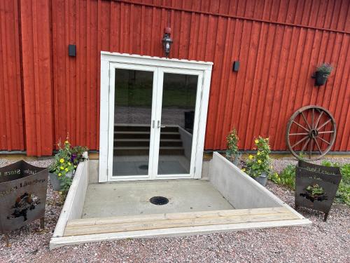 an open door in front of a red building at Magasinet Stora Långbro in Tystberga