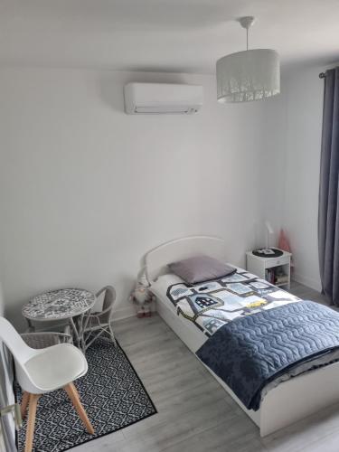 une chambre avec un lit, une table et une chaise dans l'établissement Chambre à louer, à Sainte-Geneviève-des-Bois