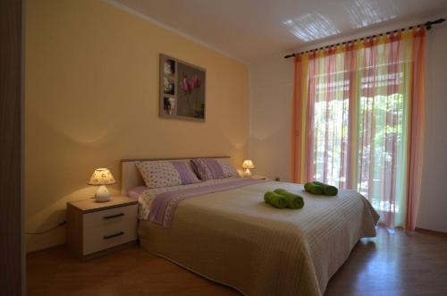 a bedroom with a bed with two green pillows on it at Apartment Kuftic - Relax Zone - Quiet Street in Rovinj
