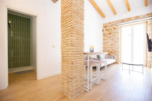 a brick pillar in a room with a table and chairs at Colón 29 Apartments in Denia