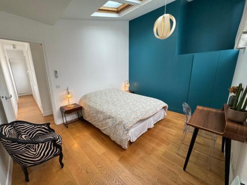une chambre avec un lit, une table et une chaise dans l'établissement Grandeur Cachée du 15e - avec parking, à Paris