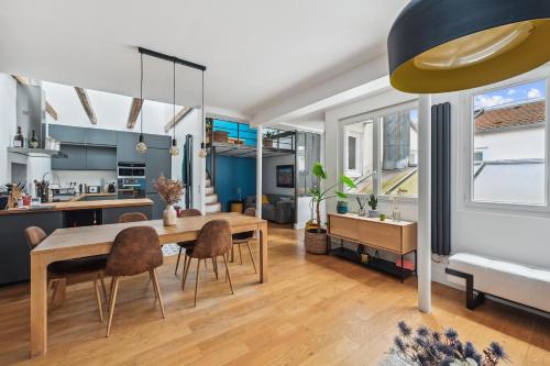 une cuisine et une salle à manger avec une table et des chaises dans l'établissement Grandeur Cachée du 15e - avec parking, à Paris