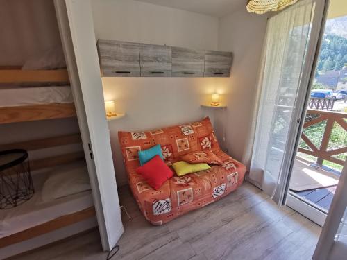 - un canapé dans une chambre avec un lit et une fenêtre dans l'établissement La Foux d'Allos - Studio 4 pers., à Allos