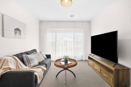 a living room with a couch and a flat screen tv at Modern Seaside Escape on the Coast in Ocean Grove