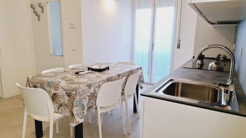 a kitchen with a table with chairs and a sink at Re Lear Expo in Verona