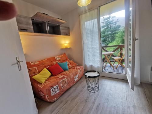 un salon avec un canapé et une grande fenêtre dans l'établissement La Foux d'Allos - Studio 4 pers., à Allos