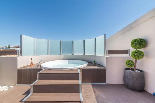 La salle de bains est pourvue d'une baignoire sur le balcon. dans l'établissement Elegant Loft with Jacuzzi, à Ayía Marína