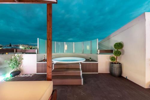 un balcon avec une table et une piscine dans l'établissement Elegant Loft with Jacuzzi, à Ayía Marína