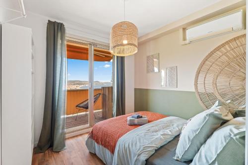 une chambre avec un lit et une grande fenêtre dans l'établissement Nice Renting - ABBAYE - Luxury Penthouse Sea View Pool Tennis Parking, à Nice