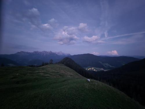 a view of a green hill with mountains in the background at Buttermilchalm in Sankt Martin am Tennengebirge