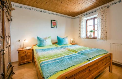 a bedroom with a large bed with blue pillows at Möderlhof in Eggstätt