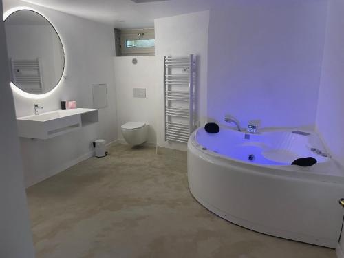 a bathroom with a tub and a sink and a mirror at La Villa 101 -TOPVACANCES -LES ISSAMBRES in Roquebrune-sur-Argens