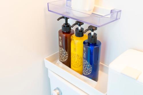 a shelf in a bathroom with four bottles on it at Kyoto Waka Hotel in Kyoto