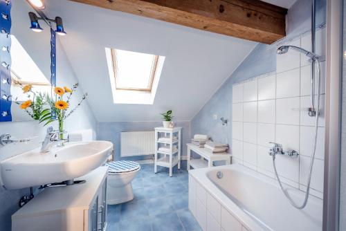 a bathroom with a sink and a tub and a toilet at Möderlhof in Eggstätt