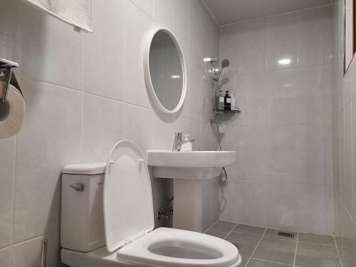 a white bathroom with a toilet and a sink at Yeongam Haeden Hanok Stay in Yeongam
