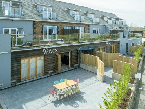 a patio with a table and chairs in front of a building at Waves Guest Suites in Castel