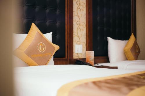 Postel nebo postele na pokoji v ubytování Grand Móng Cái Hotel