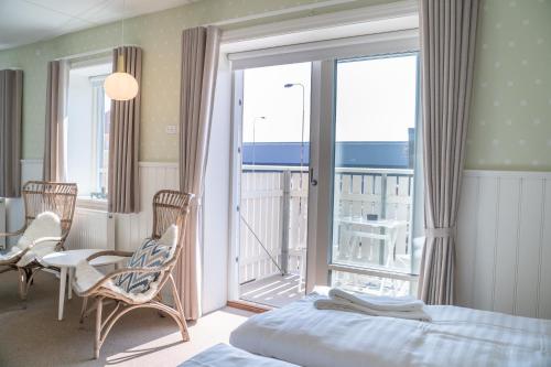 a bedroom with a bed and a balcony with a view at Hotel Marie in Skagen